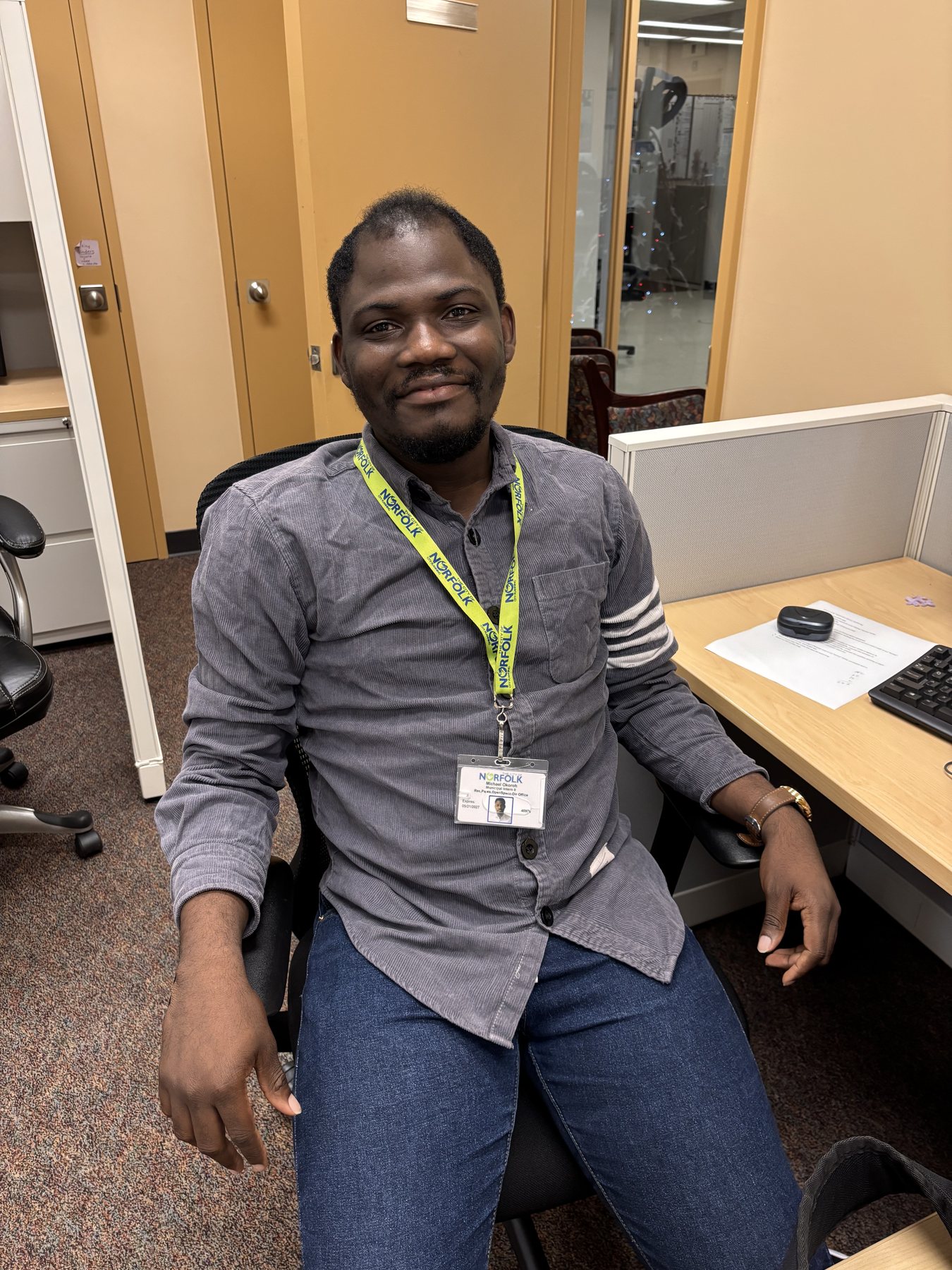 Michael Okoroh wearing a City of Norfolk lanyard at the office